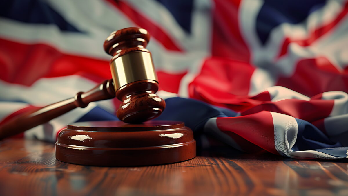 Judge wooden gavel with British flag in the background.