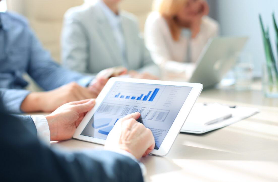 Cropped shot of a group of businesspeople looking at graphs on d