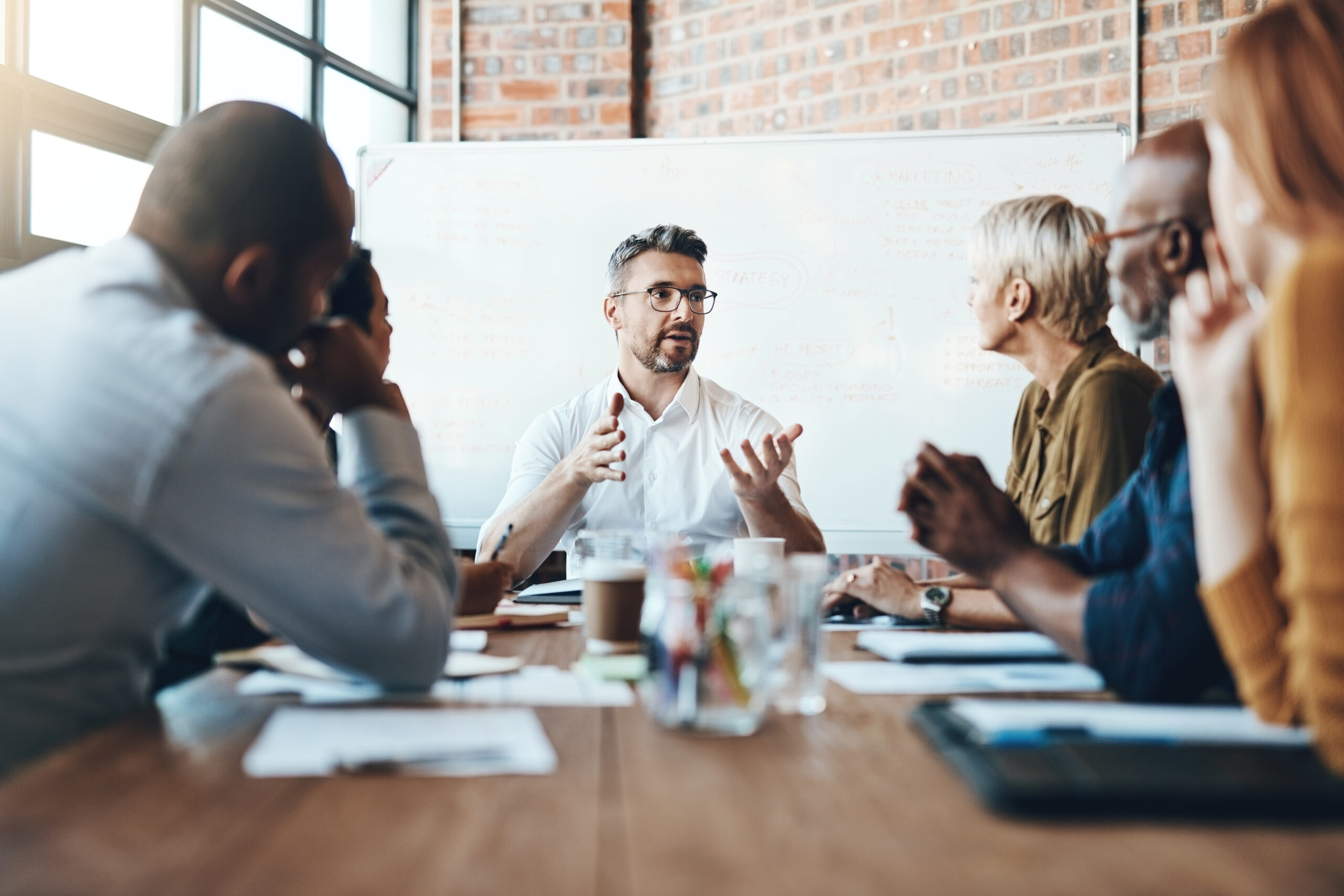 Debating before reaching a decision. Shot of a businessman leading a meeting in the boardroom.